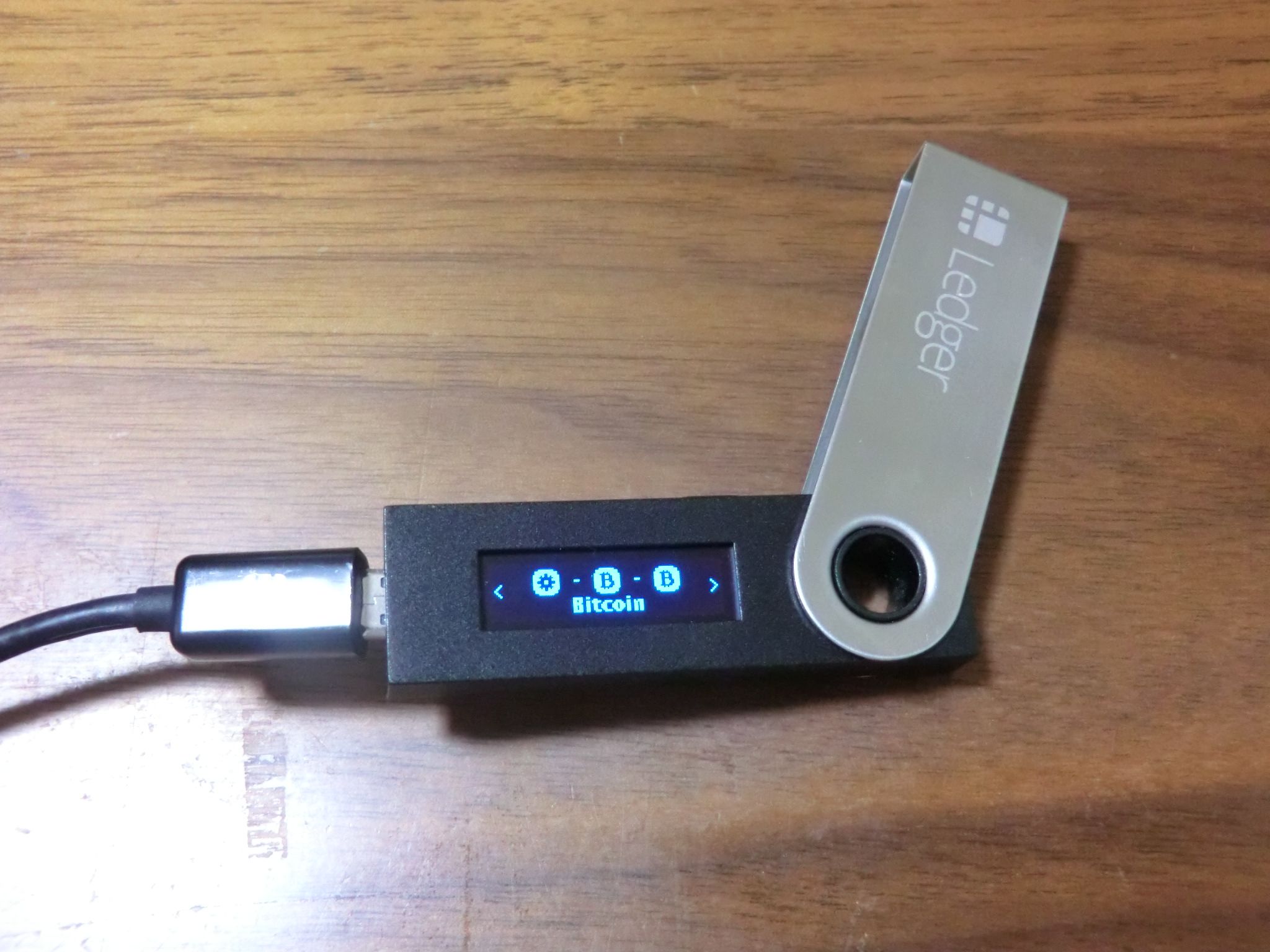 The ledger nano crypto wallet is seen on a brown surface