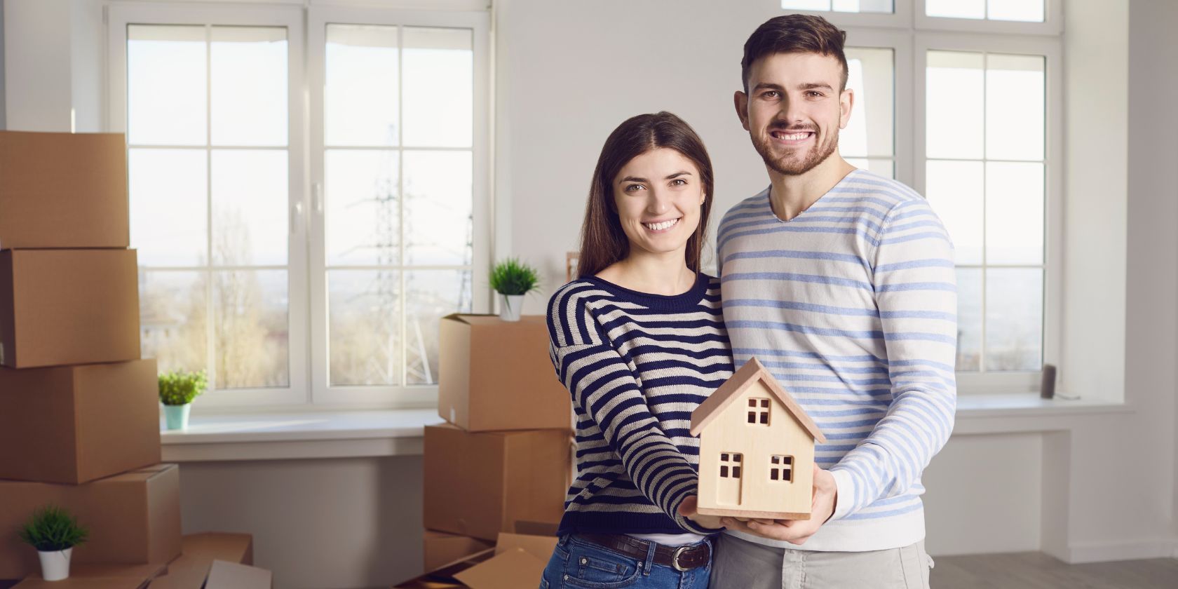 couple in an apartment holding  a wood house