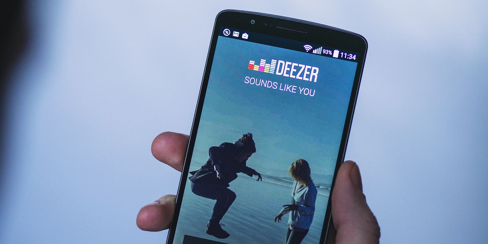 deezer app on smartphone in man's hand