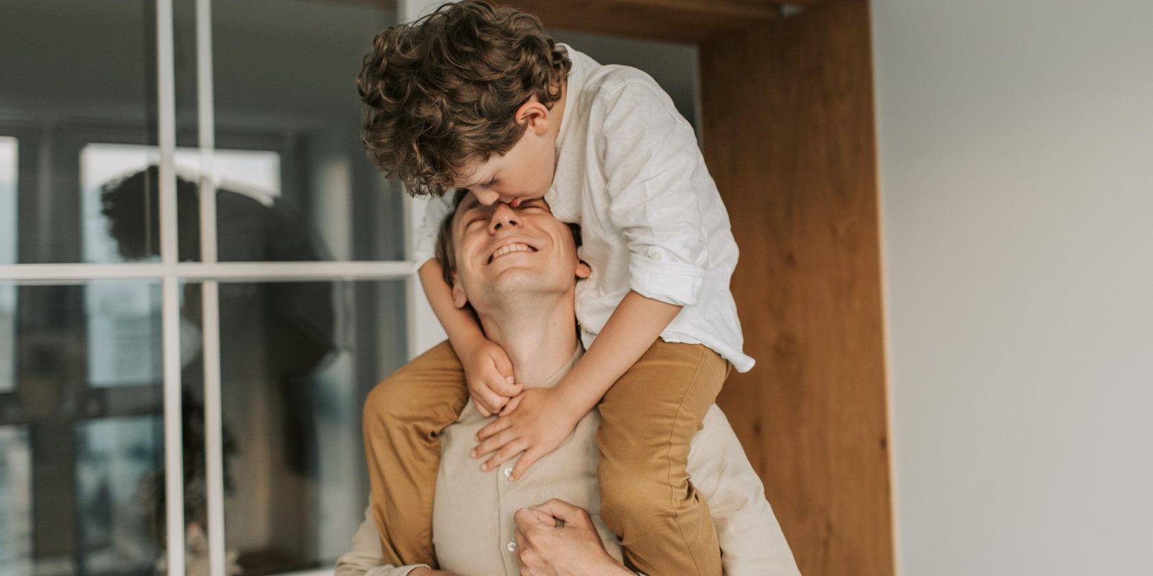 Smiling father with son sitting on shoulders