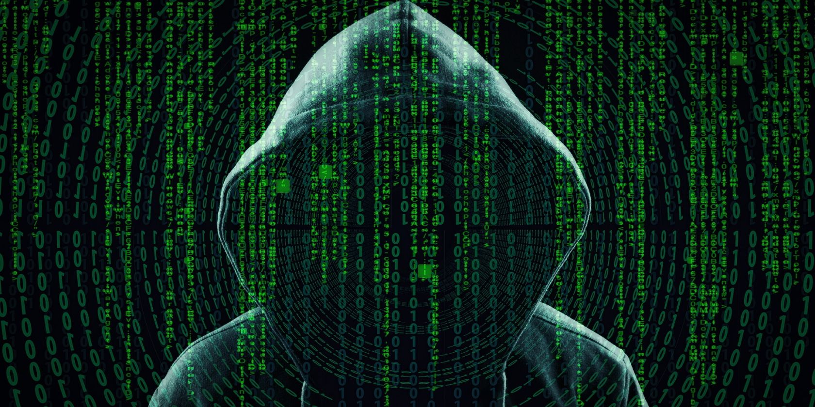 Computer code on a screen with a hooded person 
