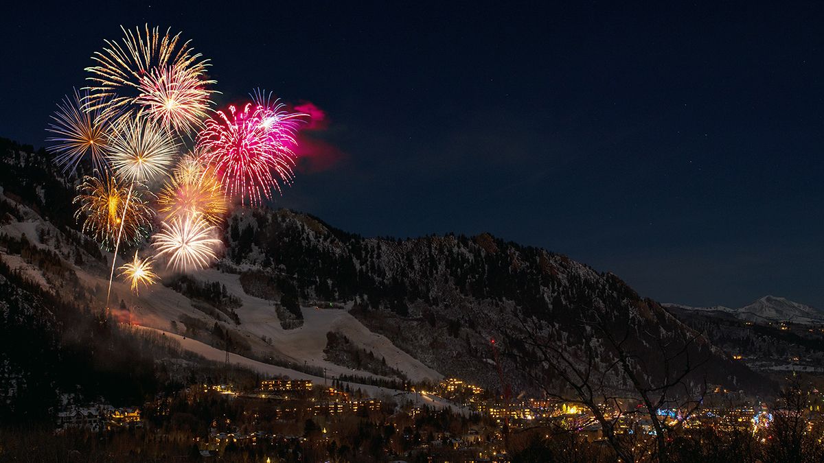 Fireworks exploding off a mountain.