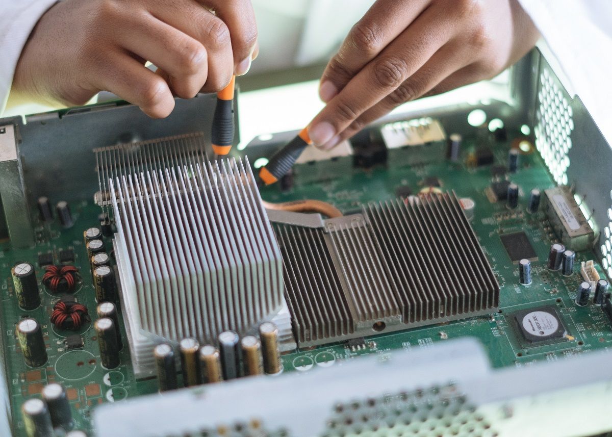 fingers of female technician repairing  a motherboard