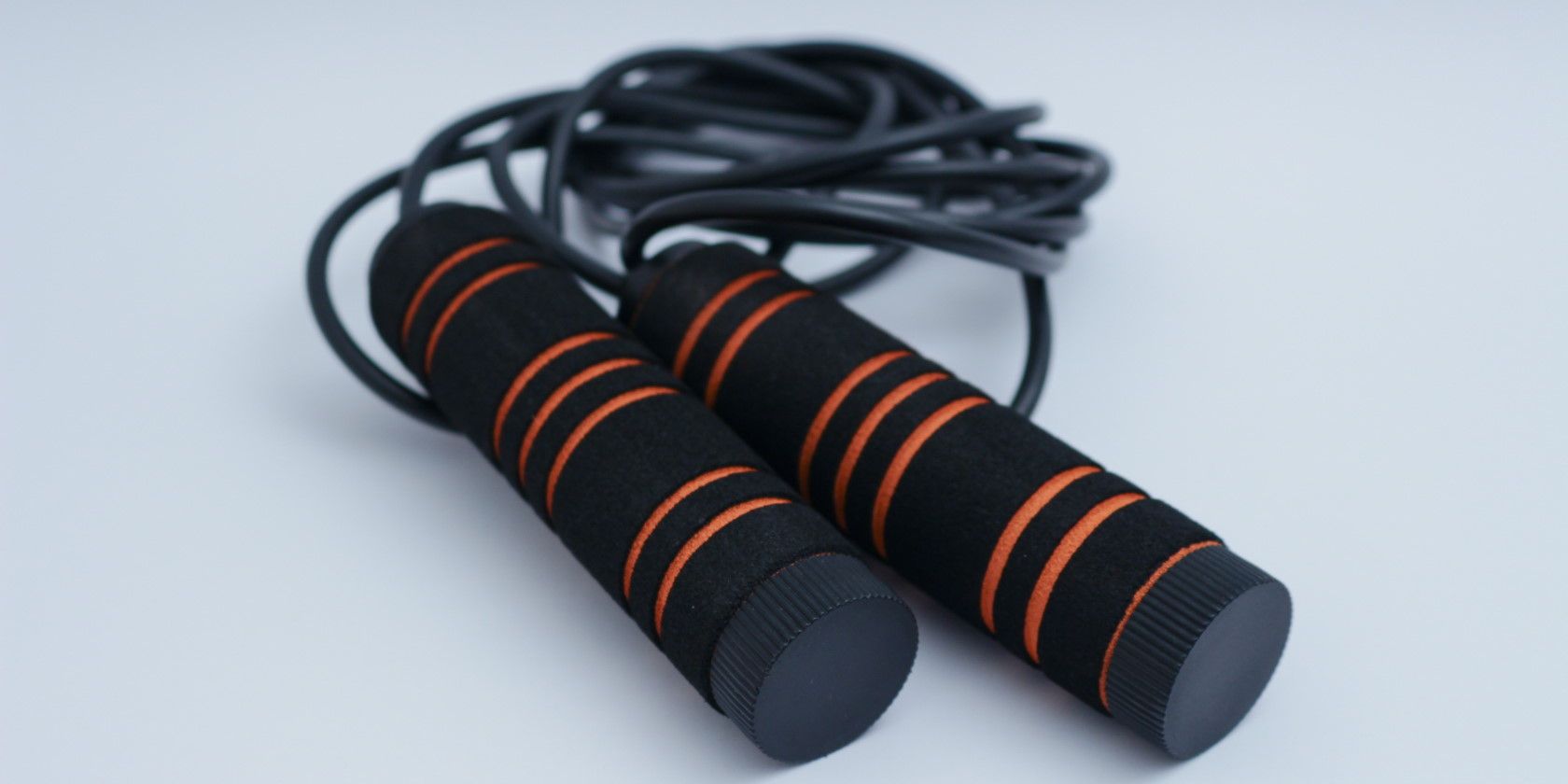 Black and orange jump rope lying on the floor