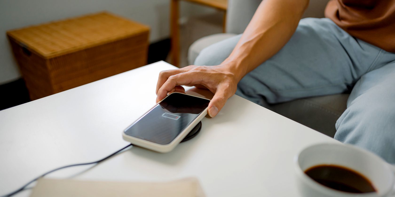 man placing smartphone on wireless charging pad feature