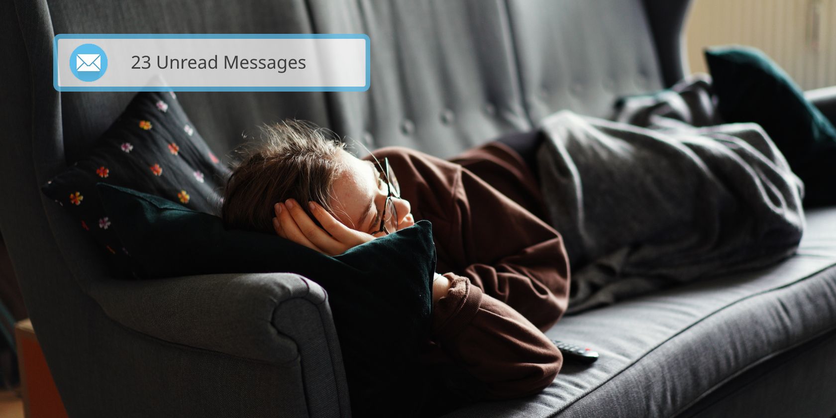 person sleeping on couch looking exhausted. A notification reminds them that they have several unread emails.