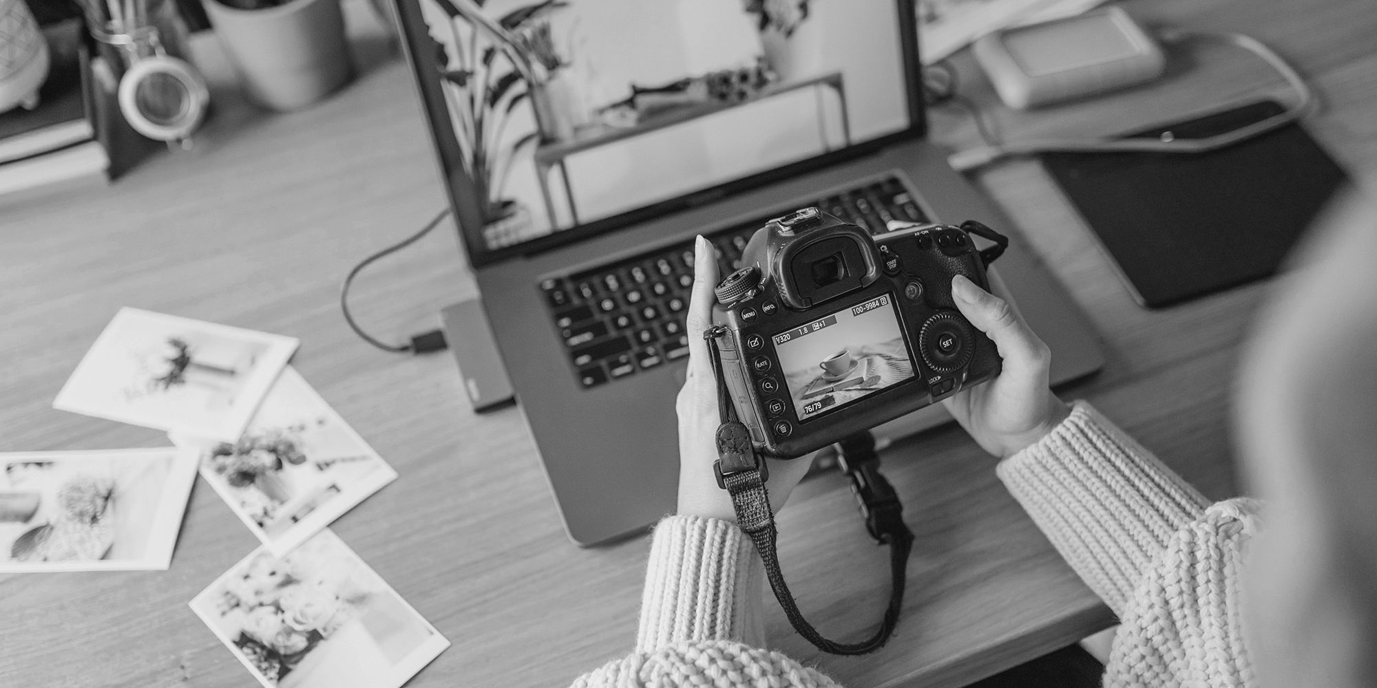 Black and white image of a woman comparing camera photo to computer's image
