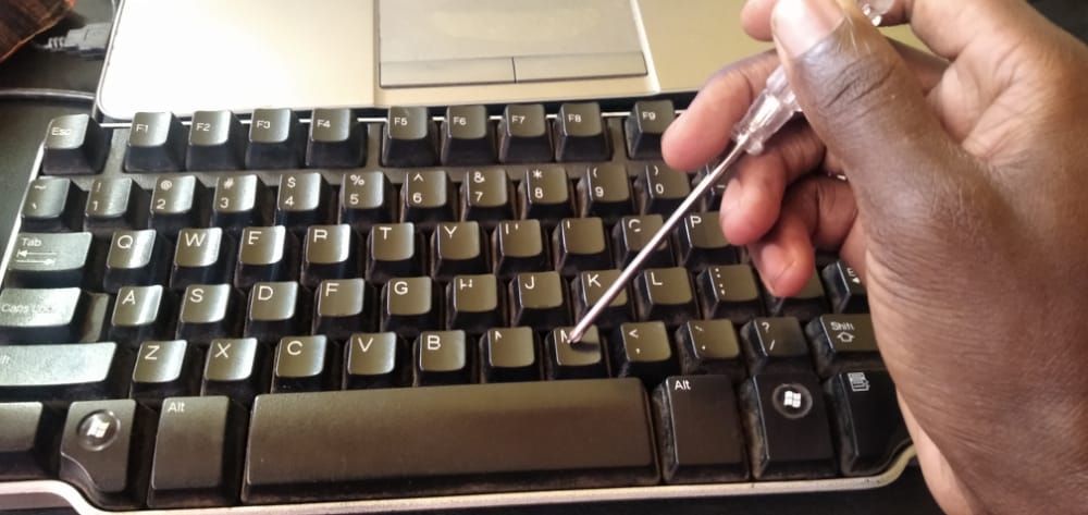 Using a screw driver to put the key back to the keyboard