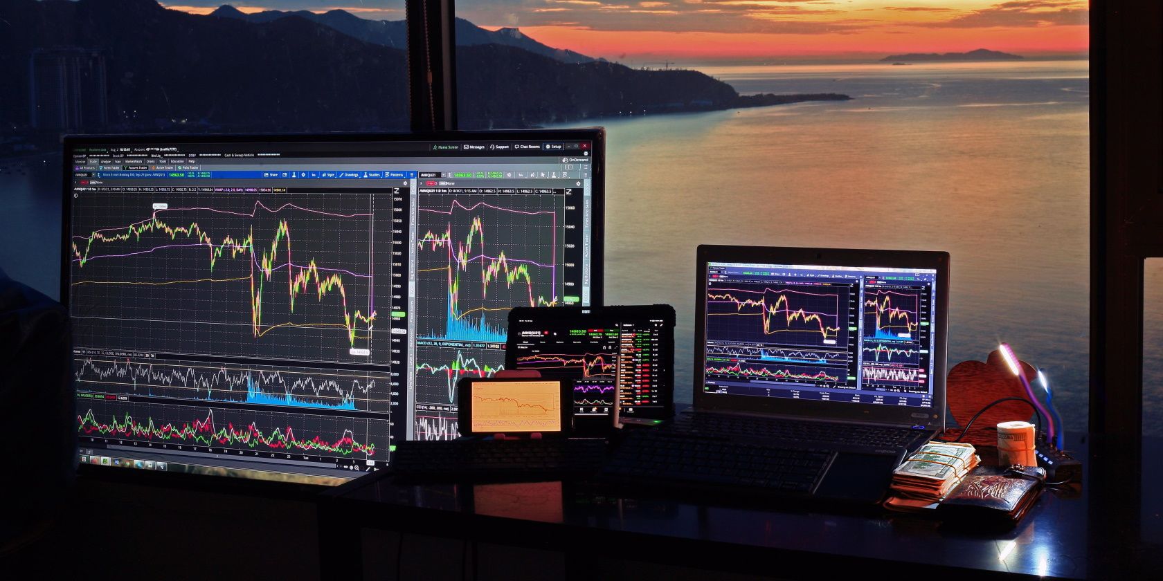 different trading charts and indicators on smart device and an ocean view 
