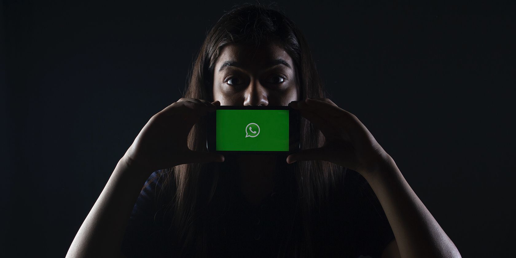 Woman holding a phone with WhatsApp on it