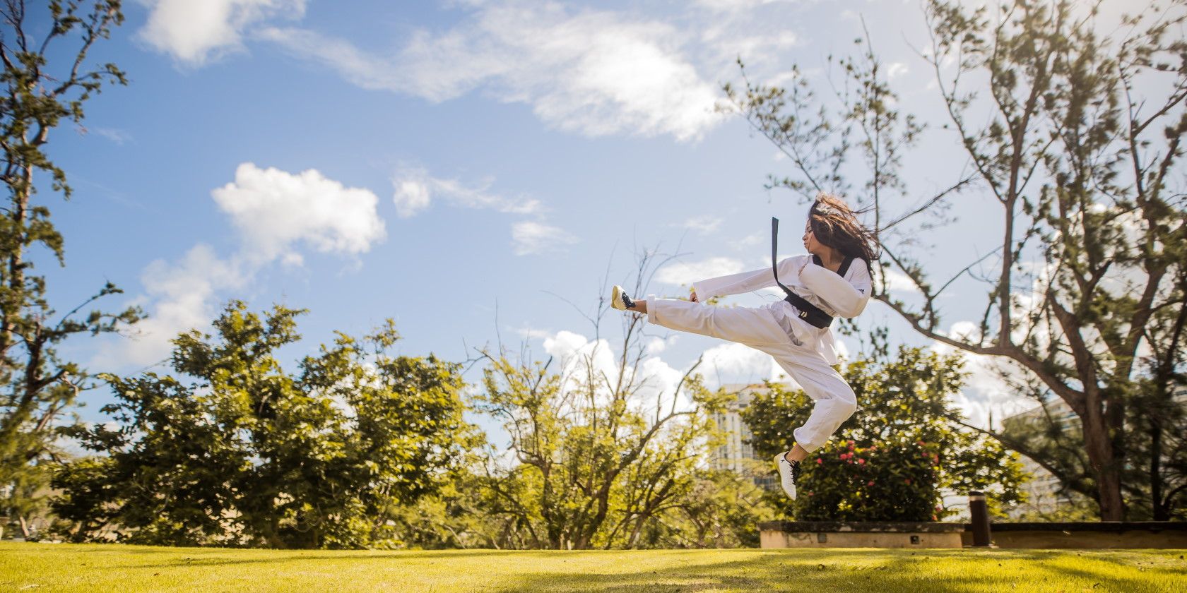 Person doing high karate kick outdoors