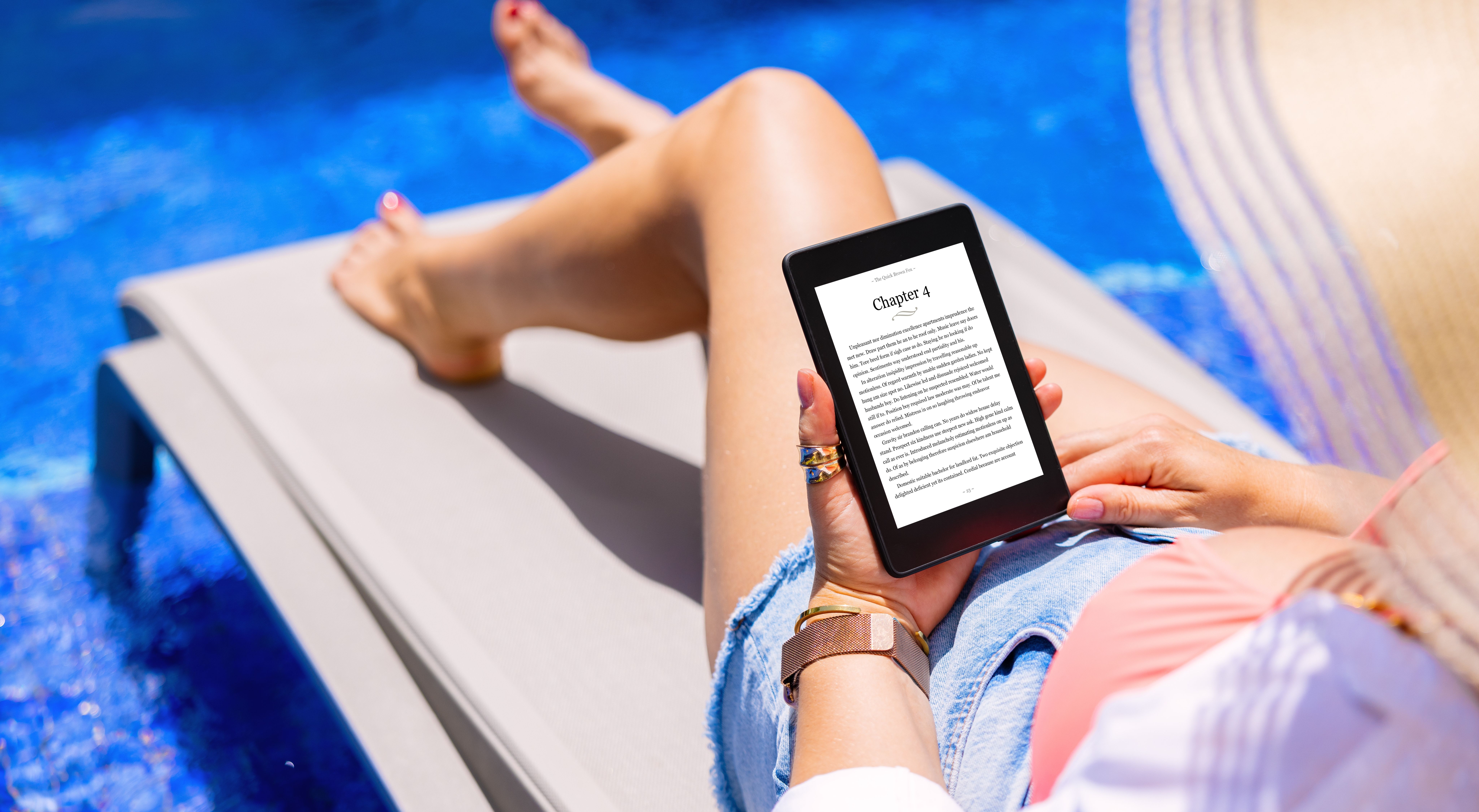 woman reading kindle by pool