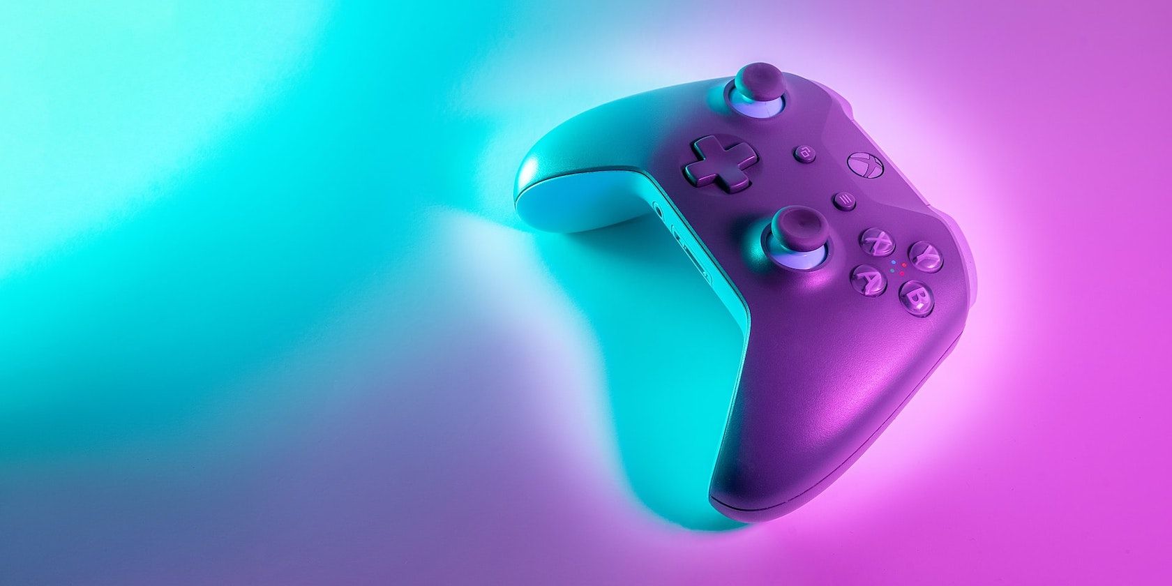 An xbox controller on a purple and blue neon background.