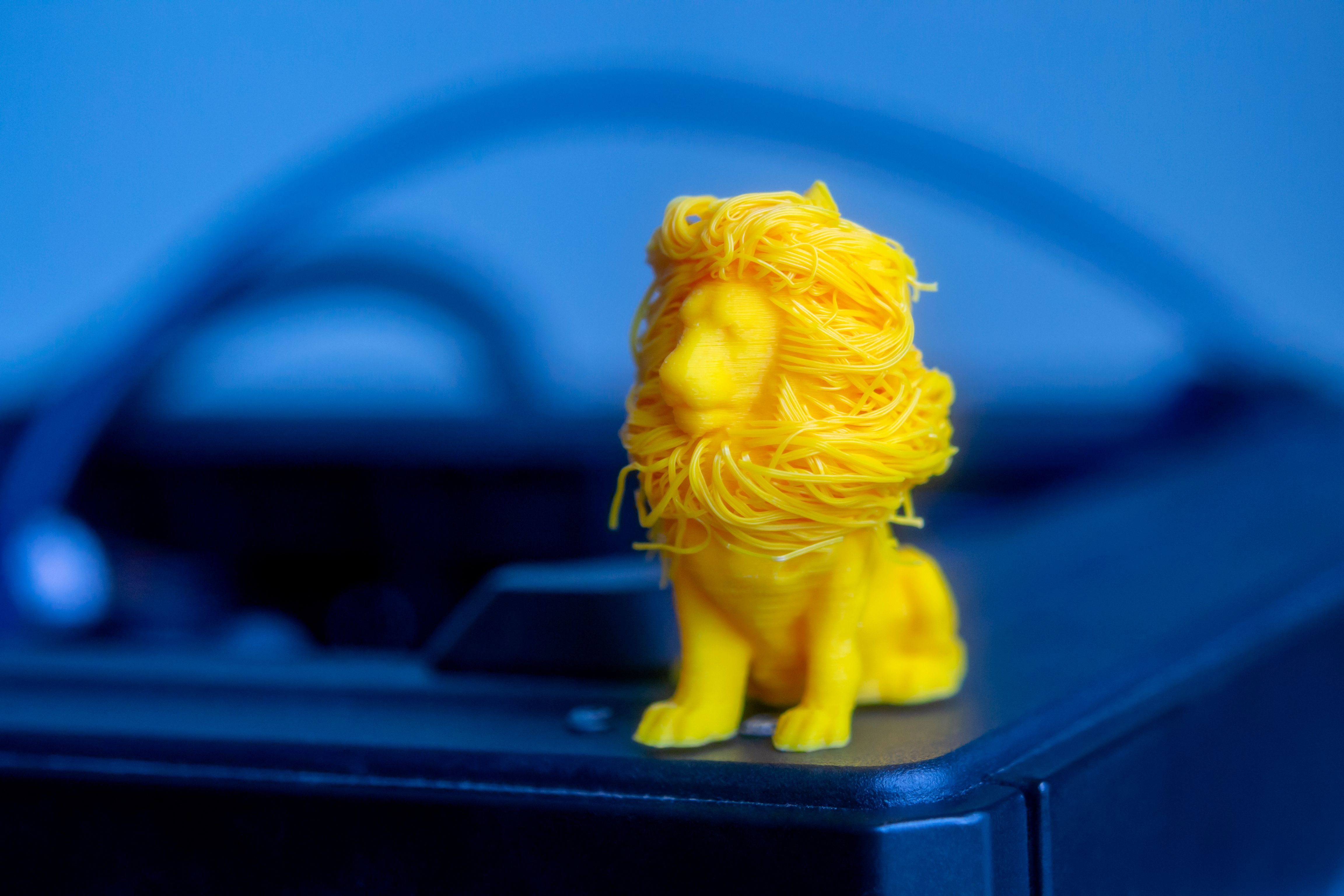 A 3D model of a lion being printed in a clean 3D printer bed