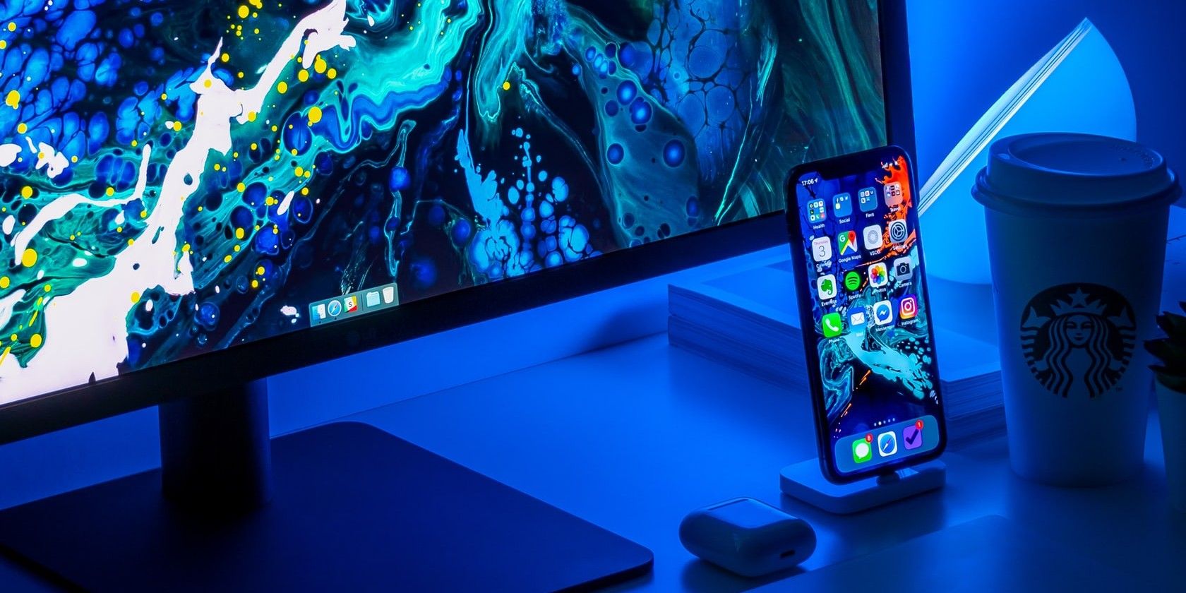Desk setup with iPhone, AirPods, and Monitor