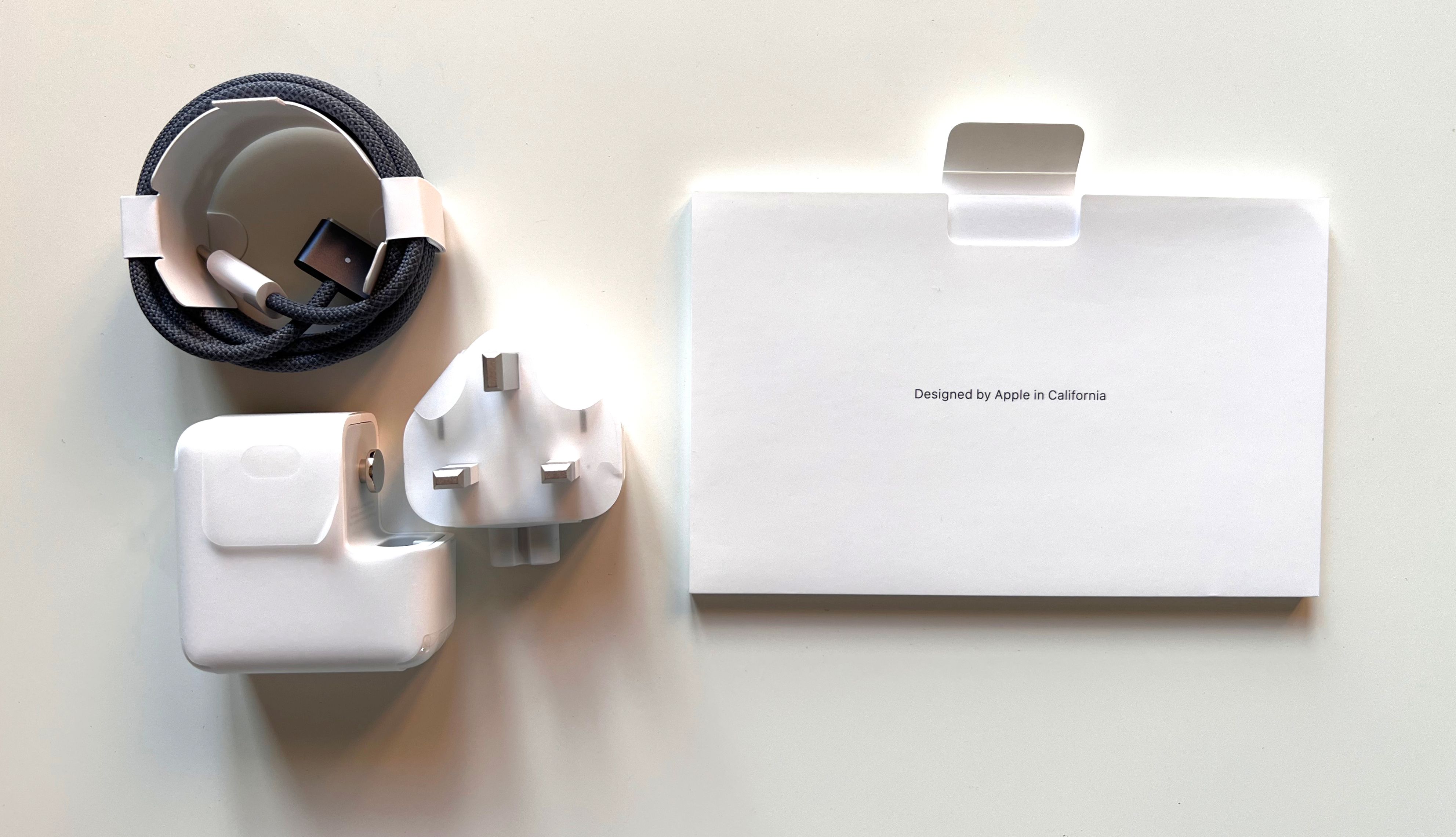 MacBook Air M2's accessories: cable, stickers, and plug