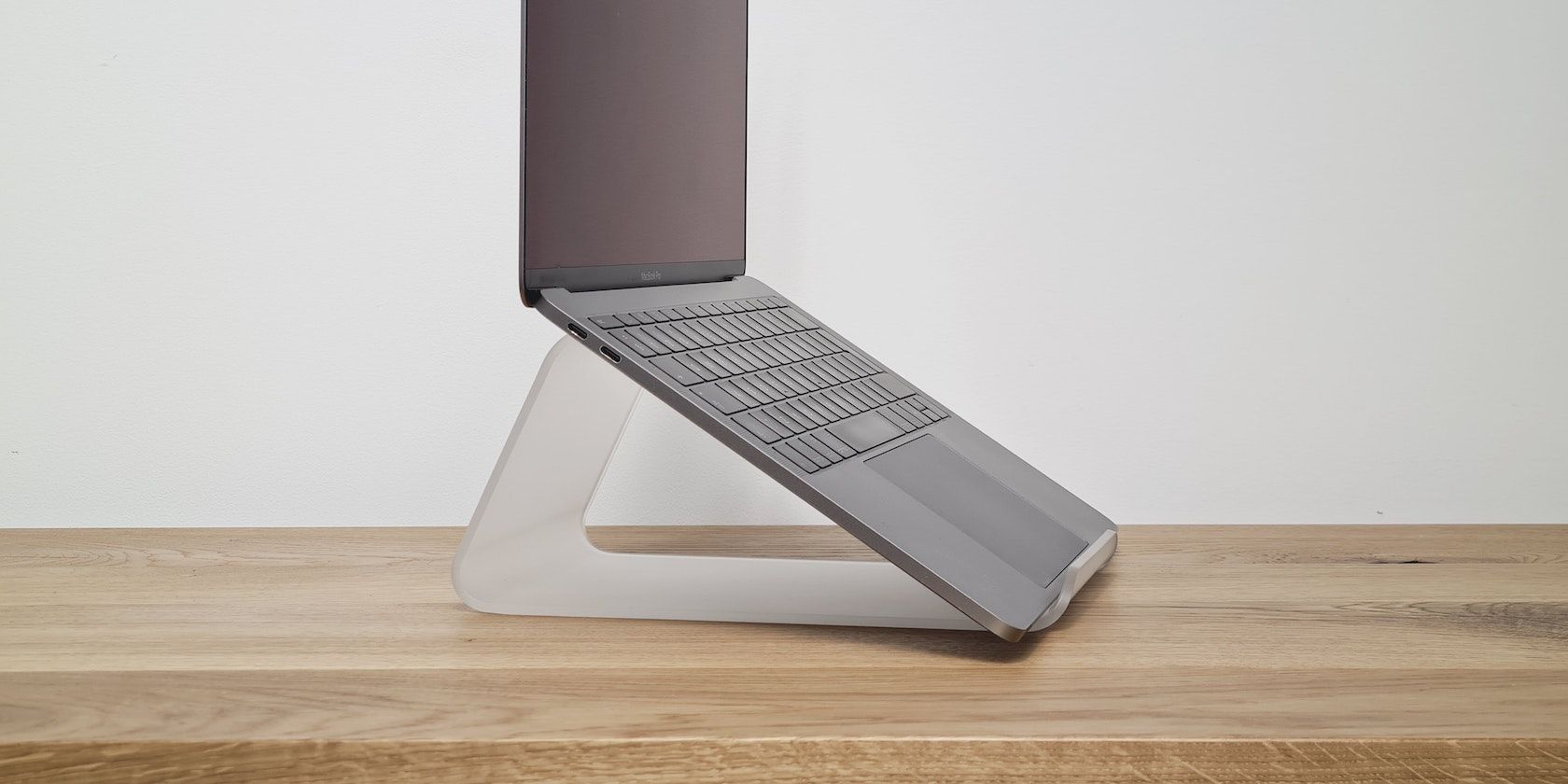 MacBook on a small triangle stand on a table