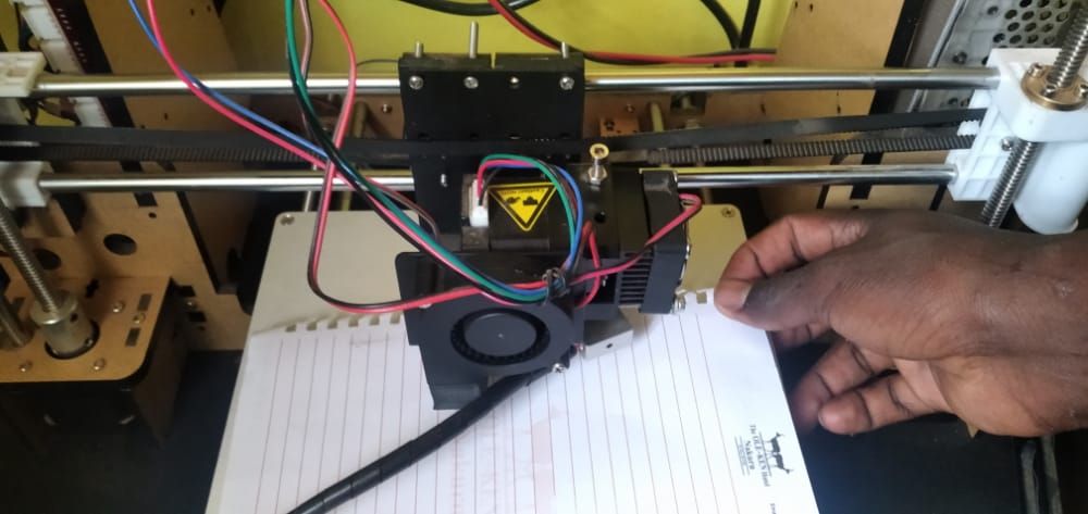 Placing a paper in between the extruder and the 3D printer bed in order to level it