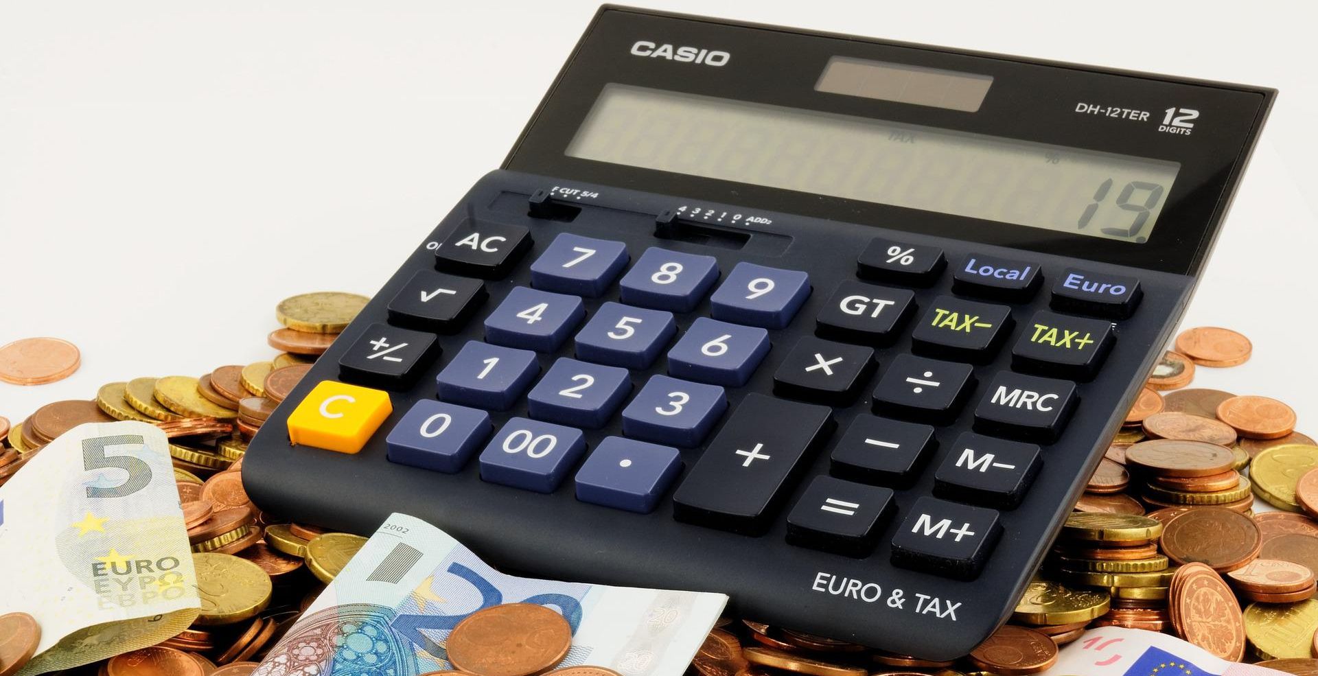 calculator lying on top of money 