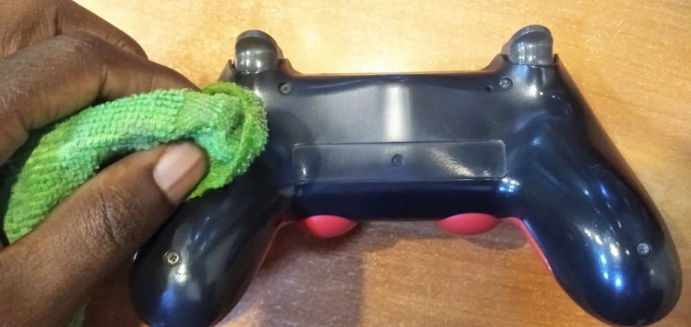 Using a pience of cloth to clean outside of the PS4 controller