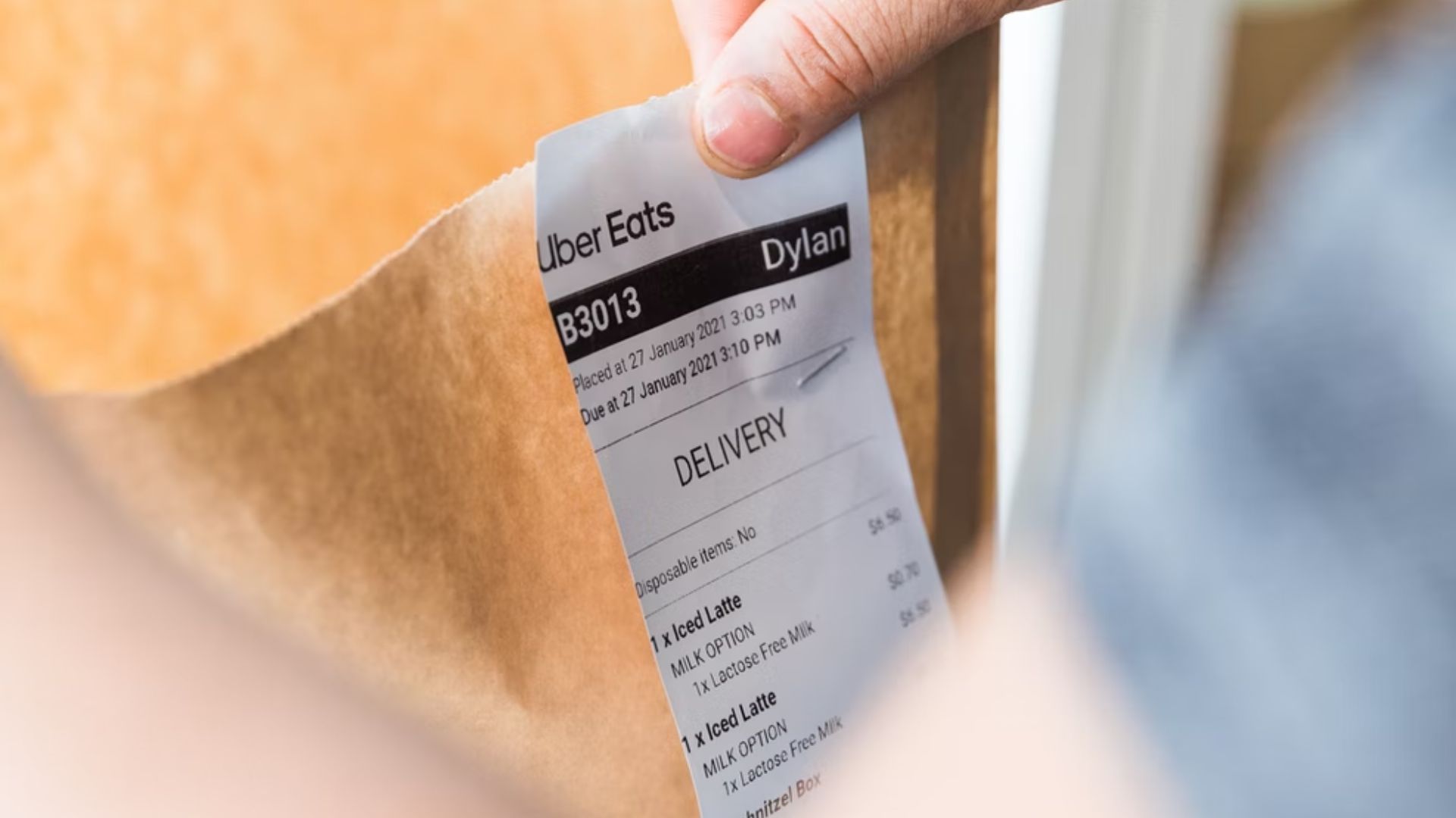 closeup of an uber eats delivery receipt stapled to a brown bag