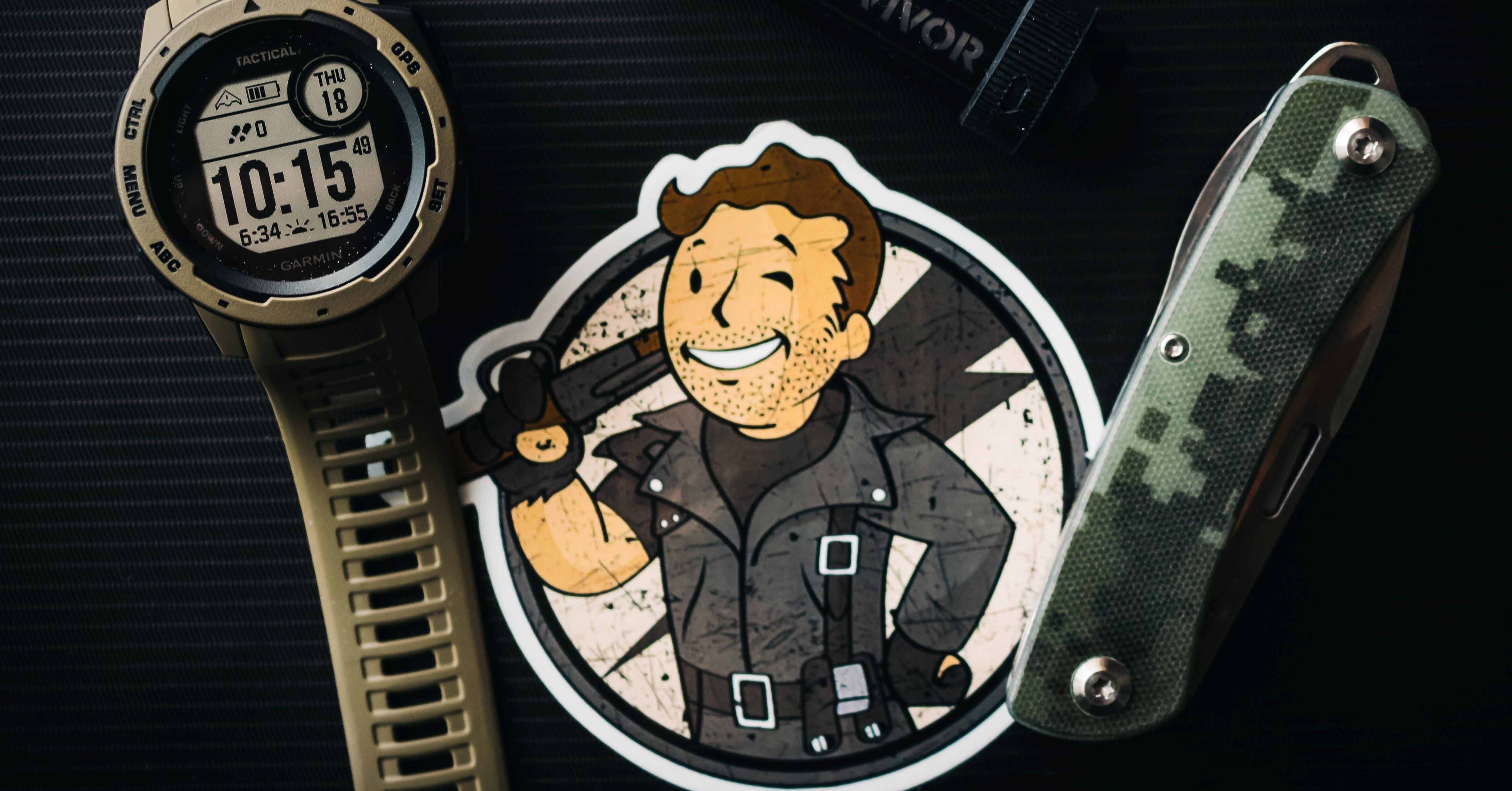 An image of Pip Boy from Fallout surrounded by survivalist equipment 