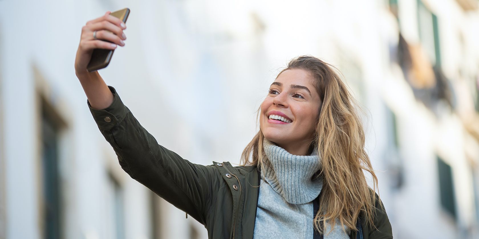 A lady taking a selfie on her smartphone