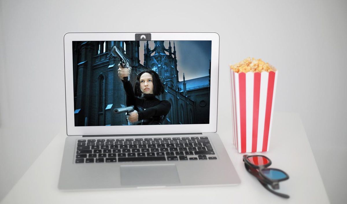 A MacBook, a bag of popcorn, and a pair of glasses.