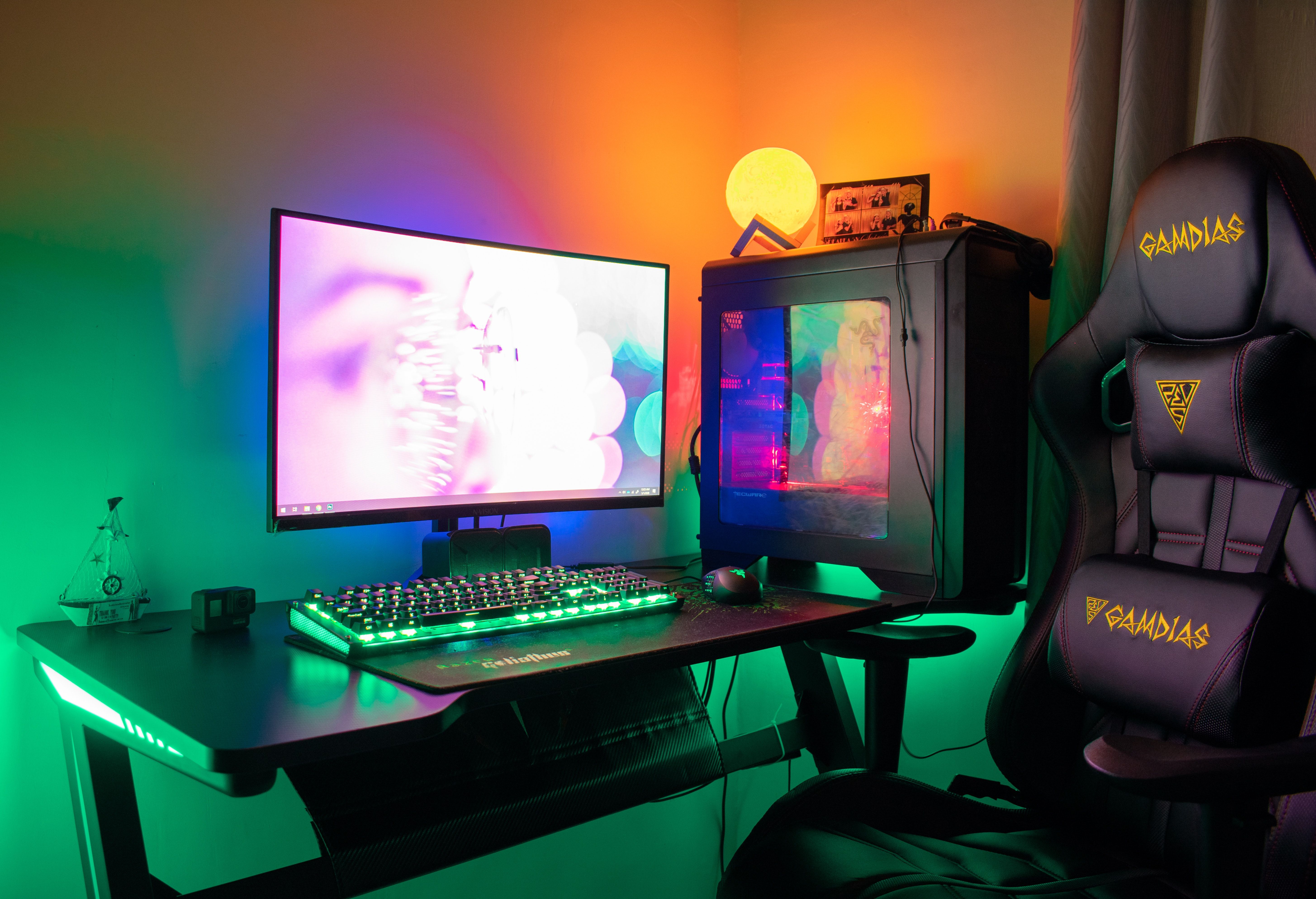 black gaming chair with orange accent and ambient lighting pc desktop setup