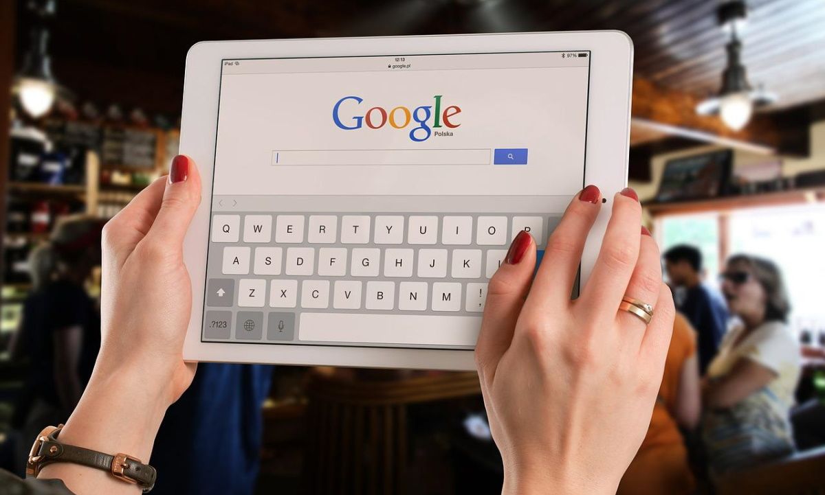 A woman holding her tablet to search on Google.