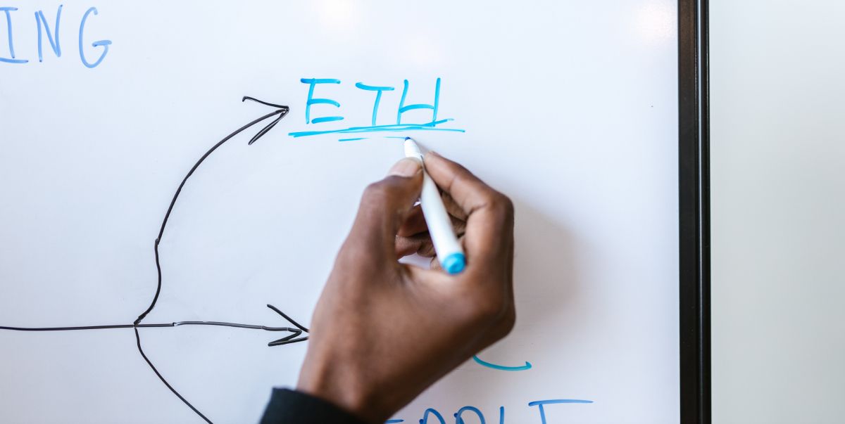 hand writing ETH on magnetic board with a green marker