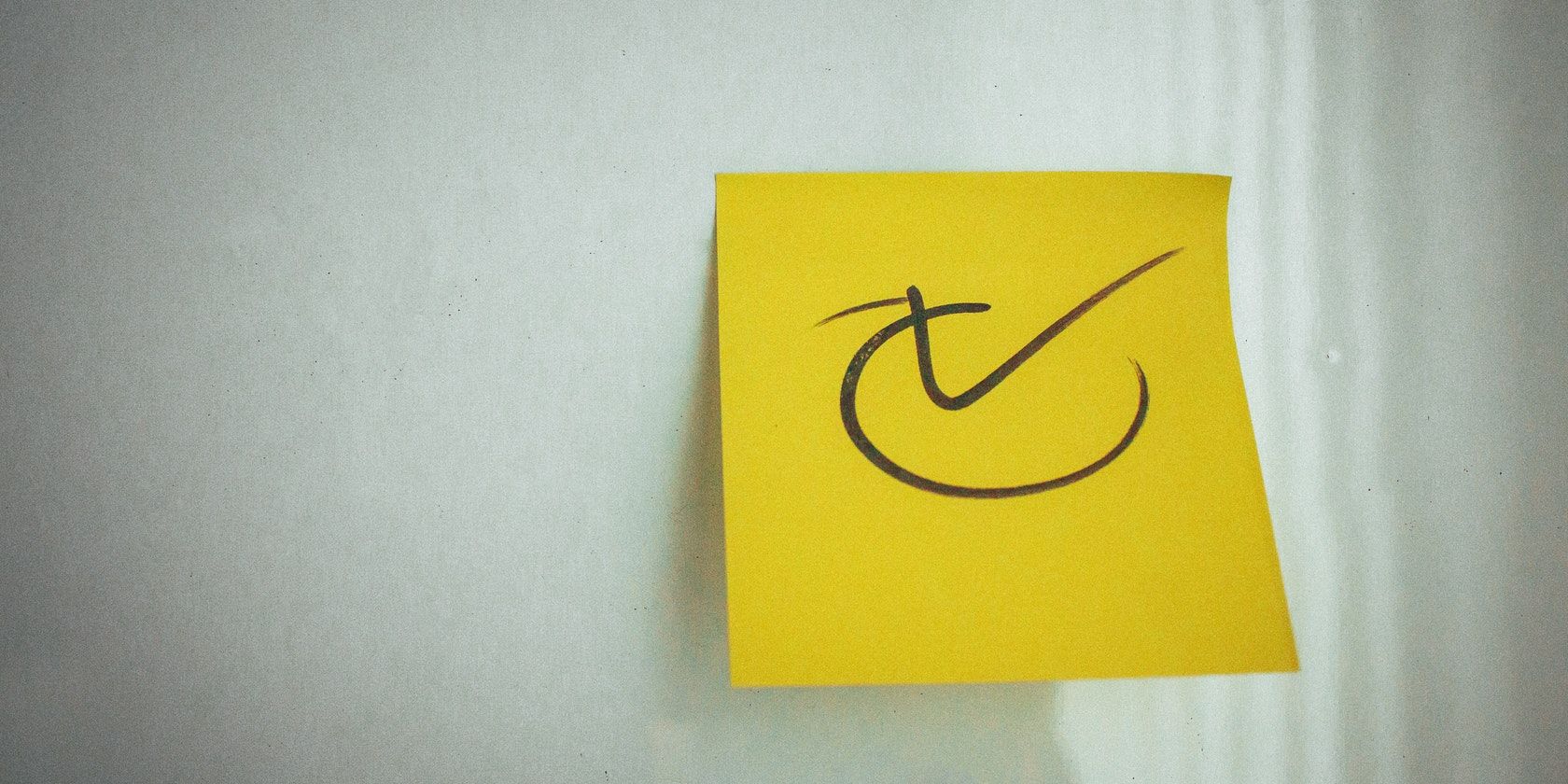 check mark on yellow sticky note