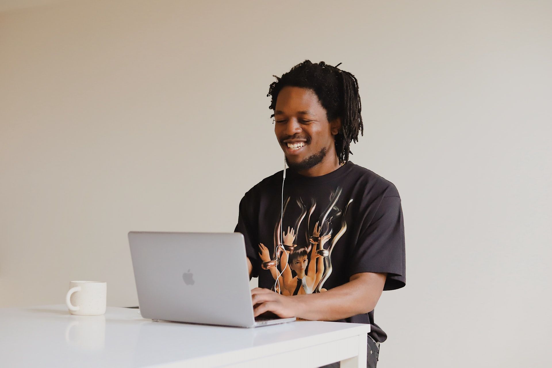 A person smiling using their macbook.