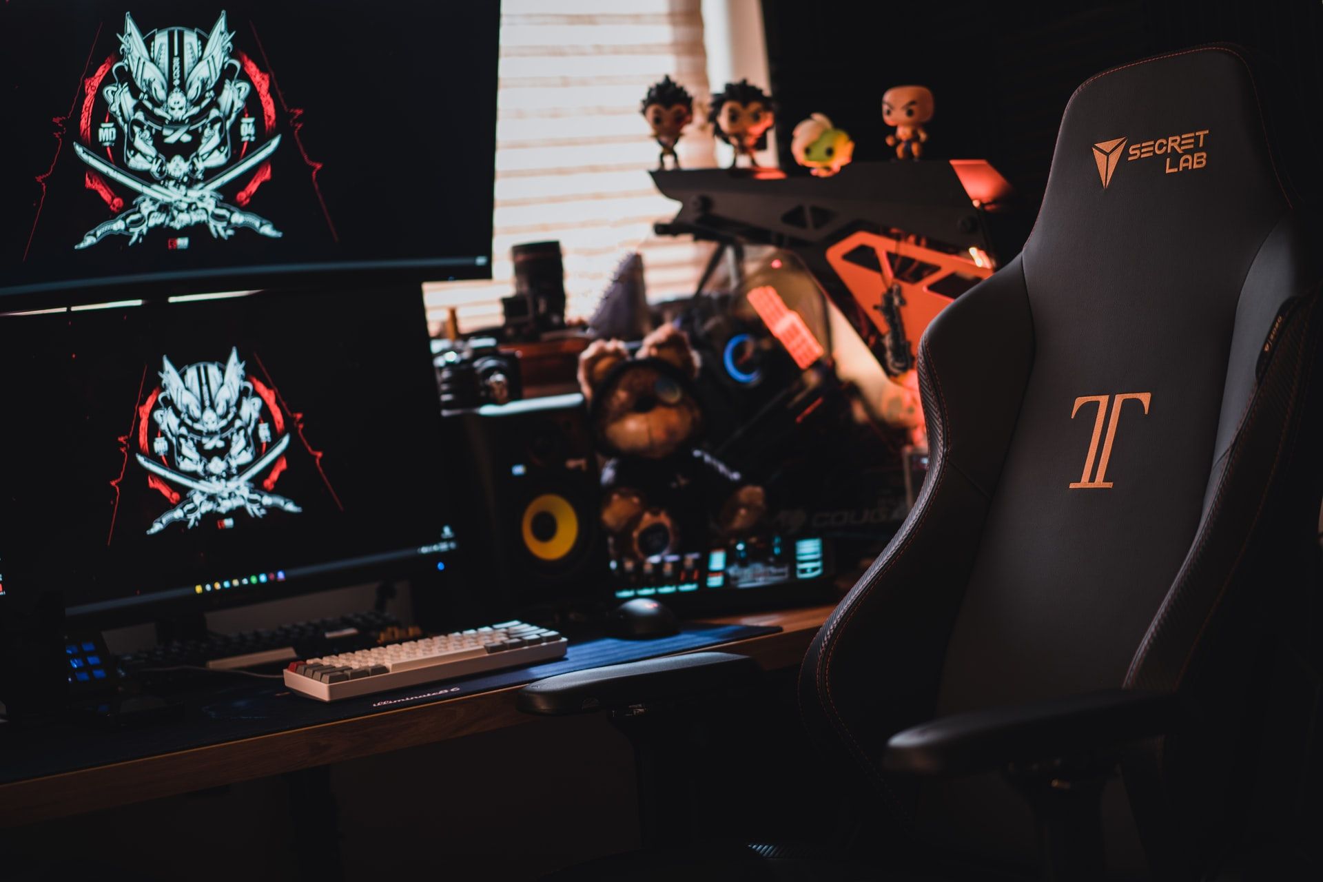 secretlab titan gaming chair in front of dual monitor pc desktop setup black and orange