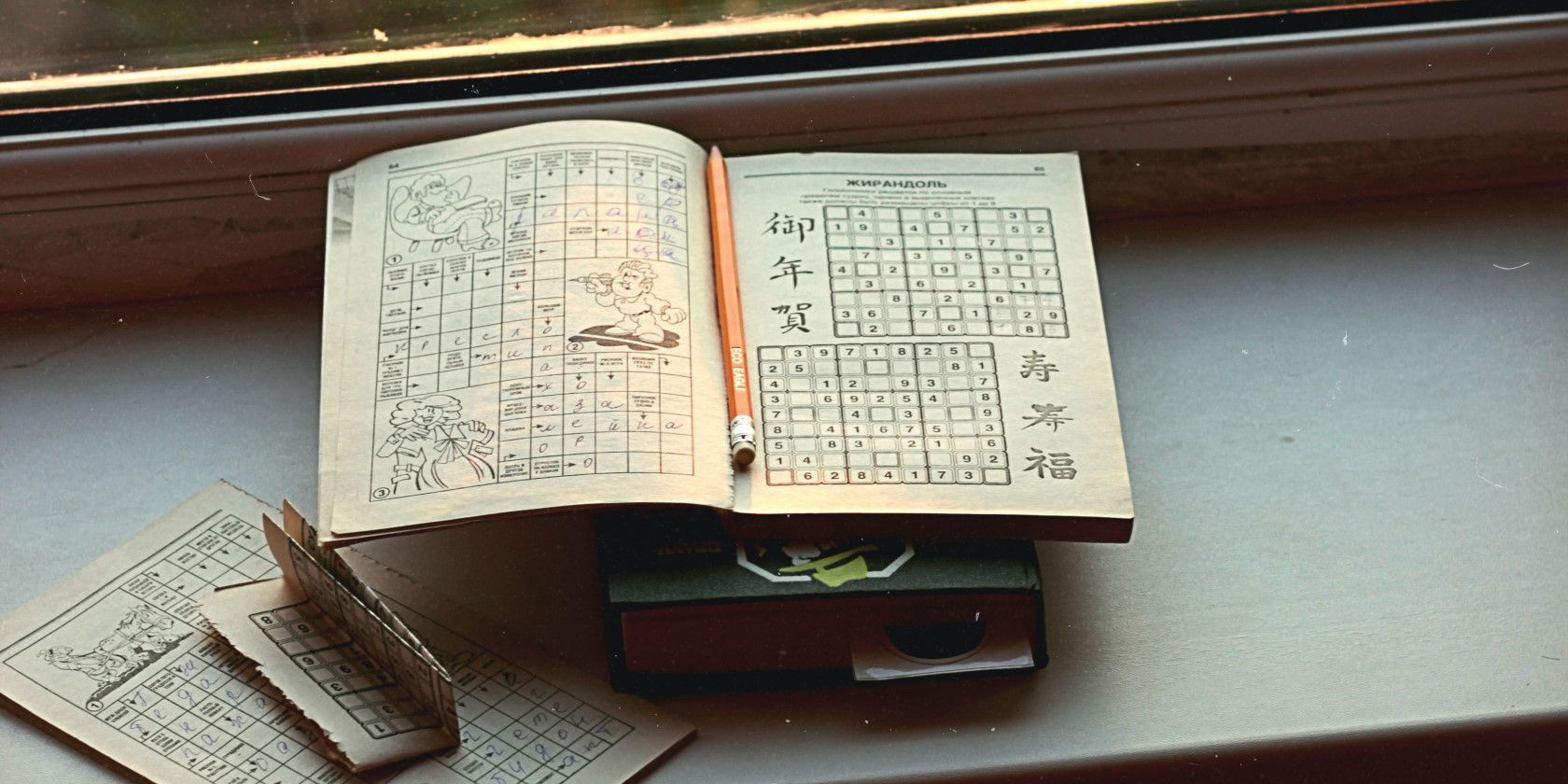 Open Sudoku puzzle book on windowsill