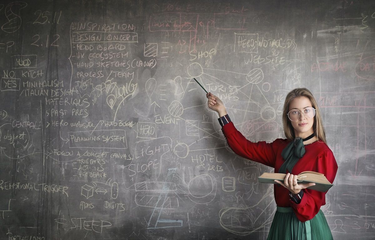 female teacher or professor points to chalkboard