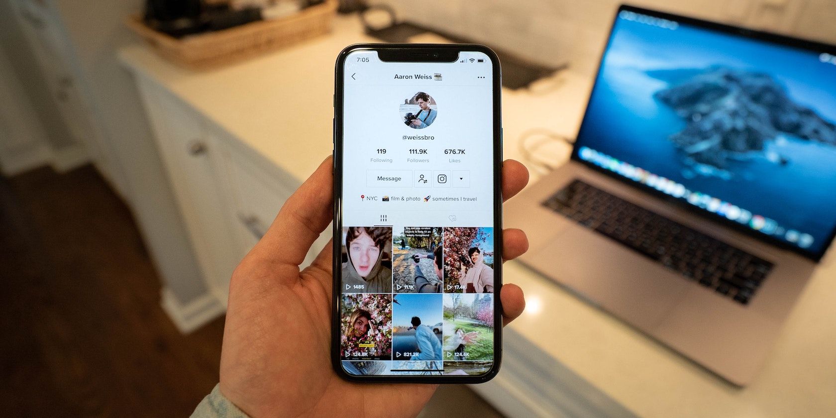 TikTok page open on iPhone with laptop in the background