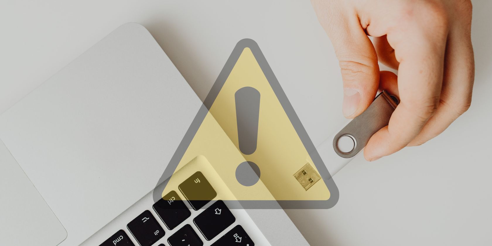 usb being inserted into laptop behind translucent alert logo 
