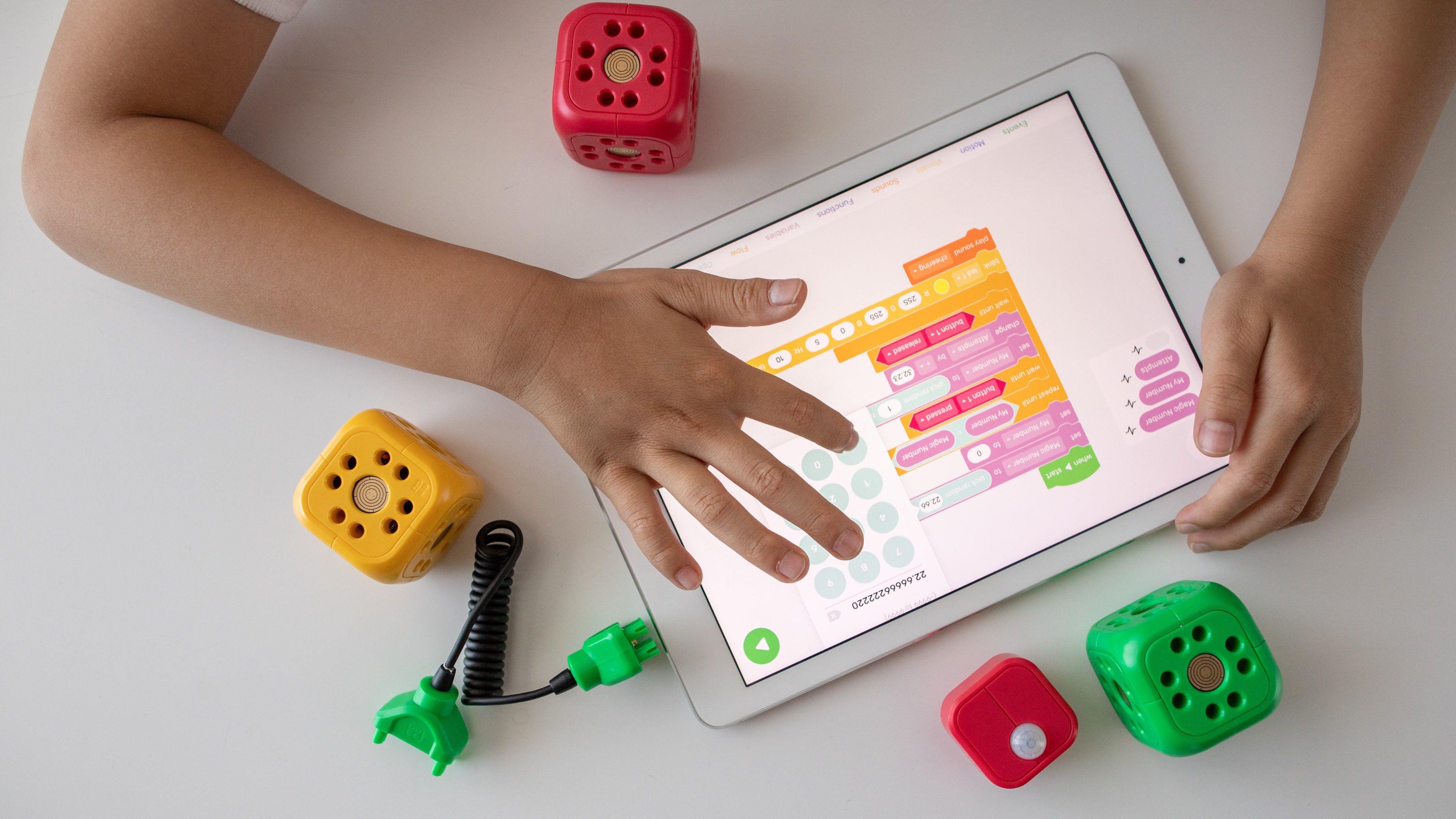 یک کودک در حال تعامل با یک برنامه iPad برای برنامه نویسی بصری