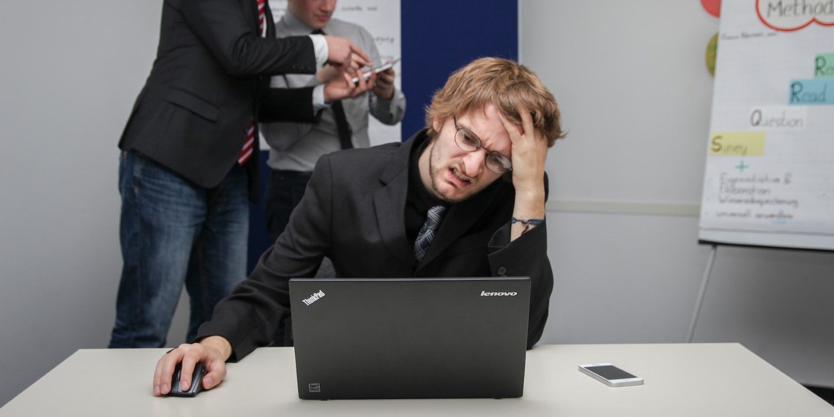 A man sitting on a chair using a gray laptop