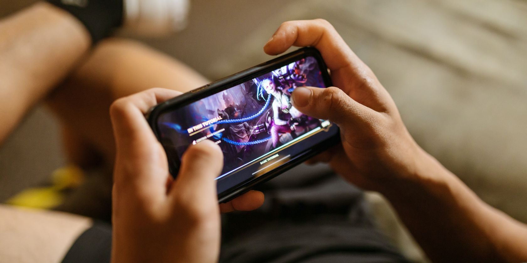 Guy playing mobile game on couch