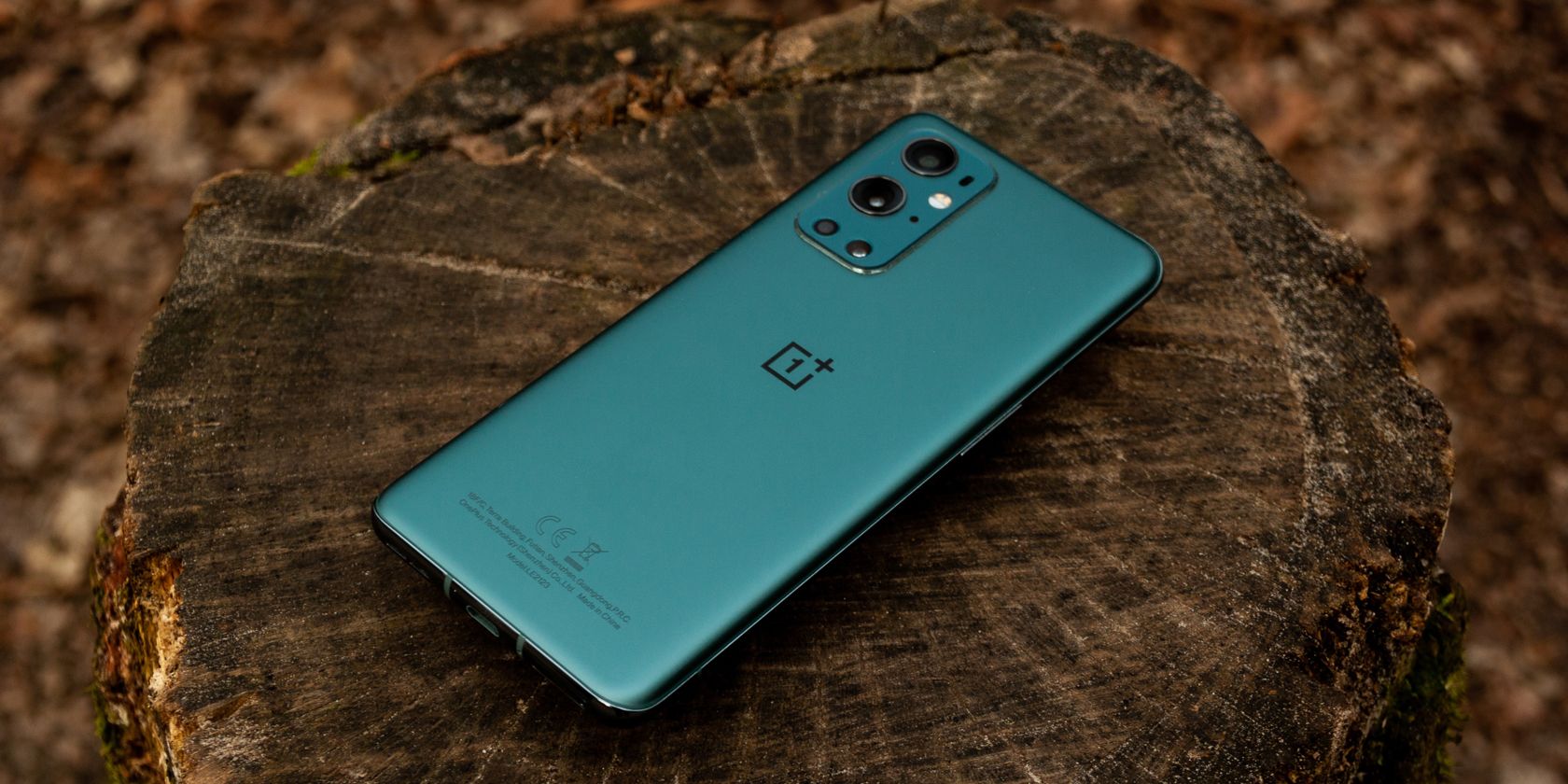 A green OnePlus phone on a timber log