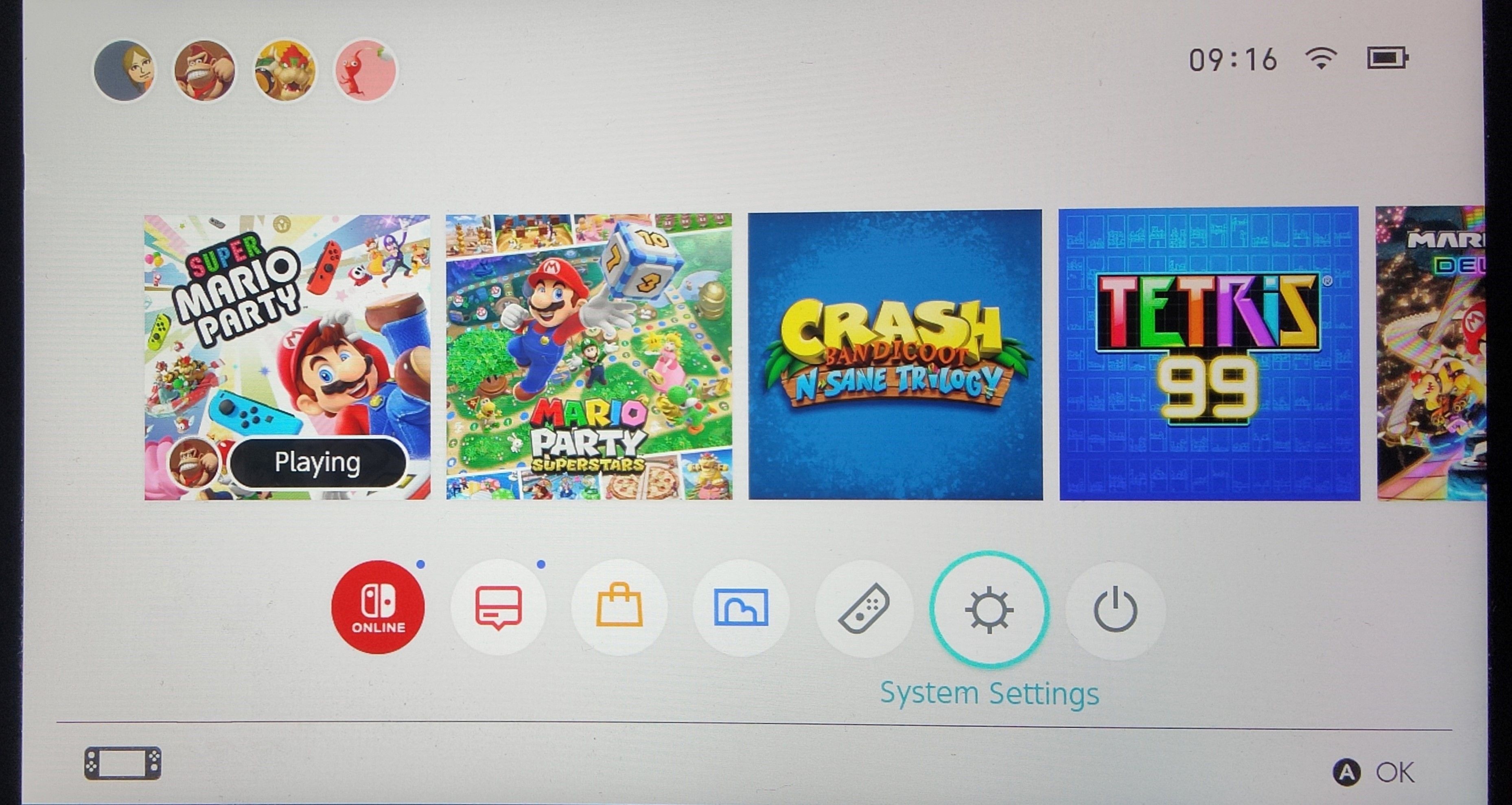 A photo of the Nintendo Switch Home screen with System Settings highlighted