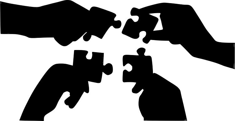 Image of people holding puzzle pieces that fit together