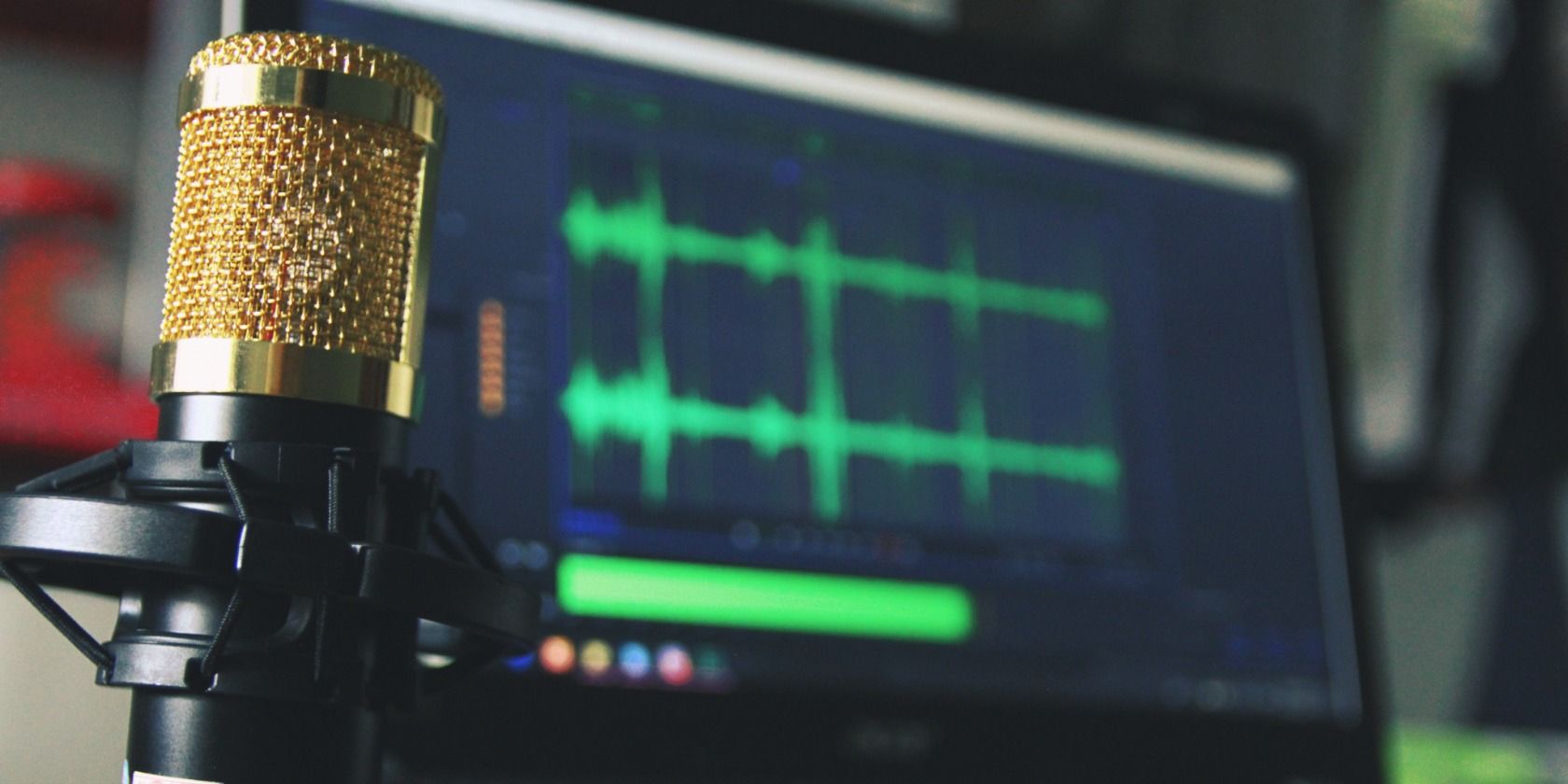 Gold microphone in front of laptop displaying music production software