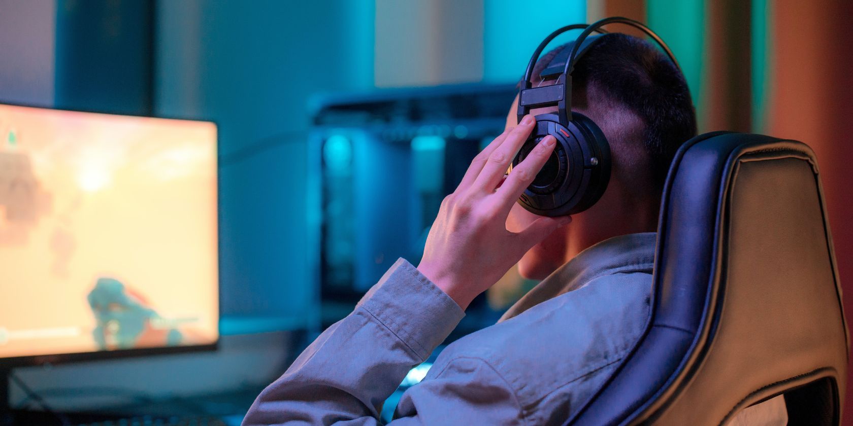 Person playing video game with voice chat through headphones