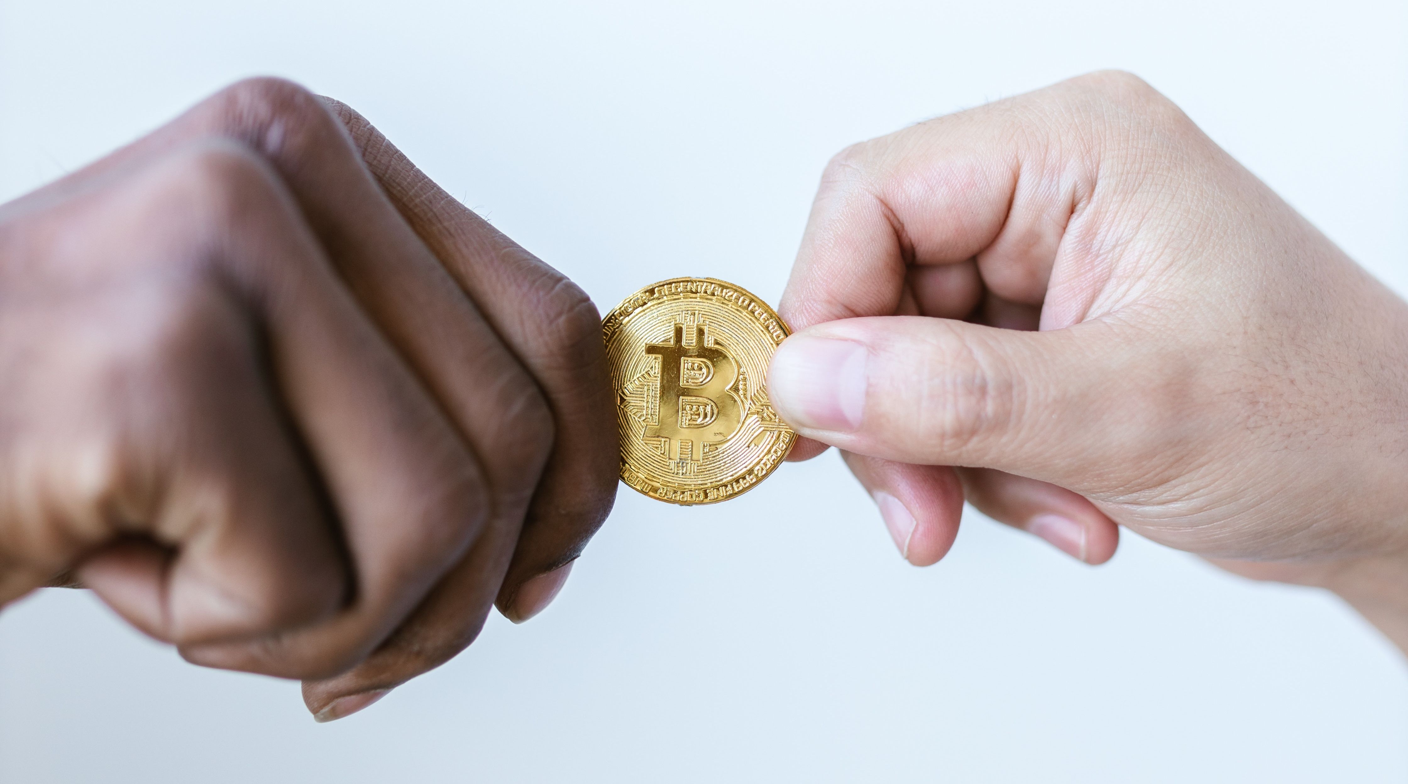 two people holding one bitcoin