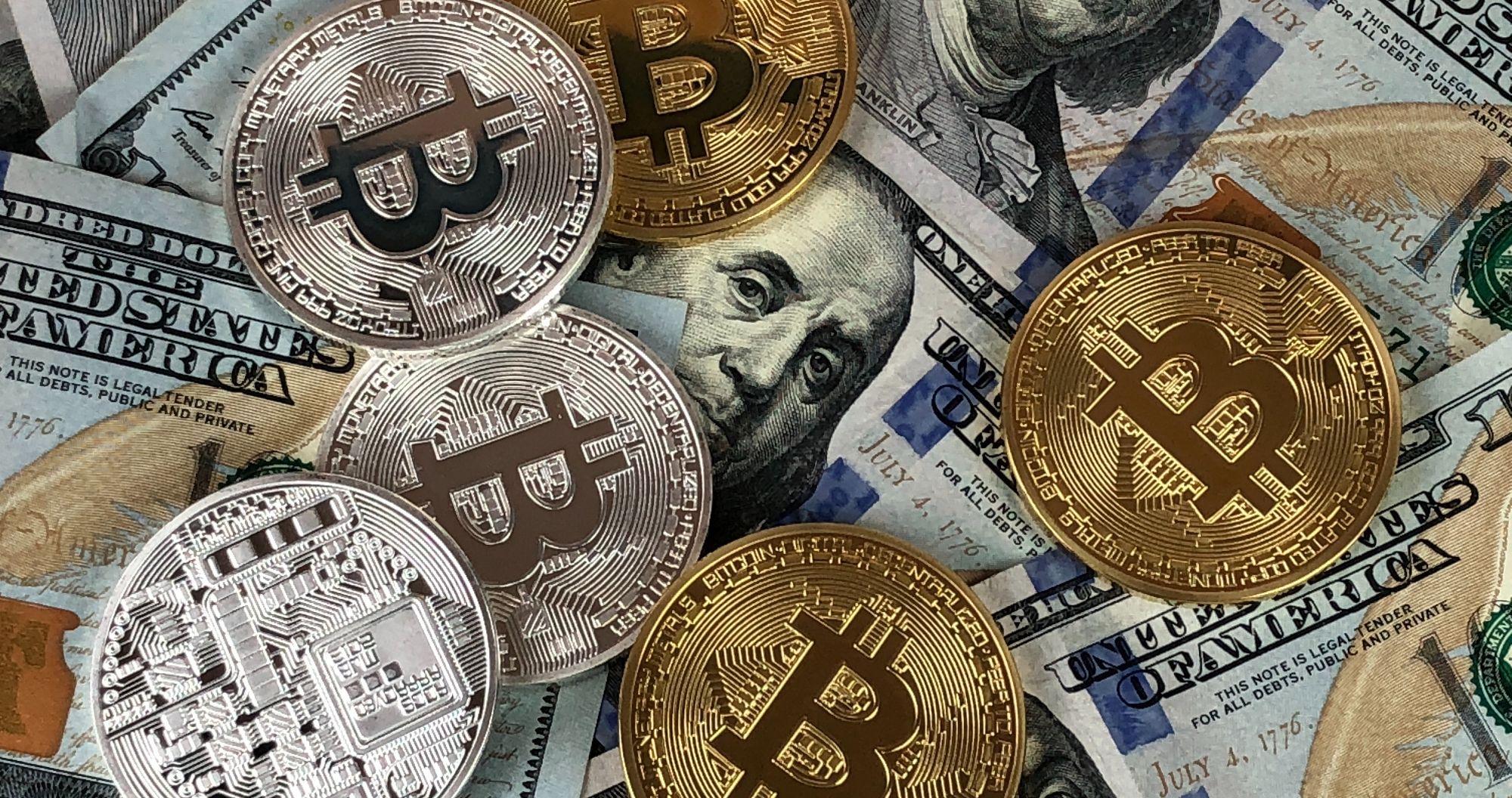 bitcoins on top of hundred dollar bills
