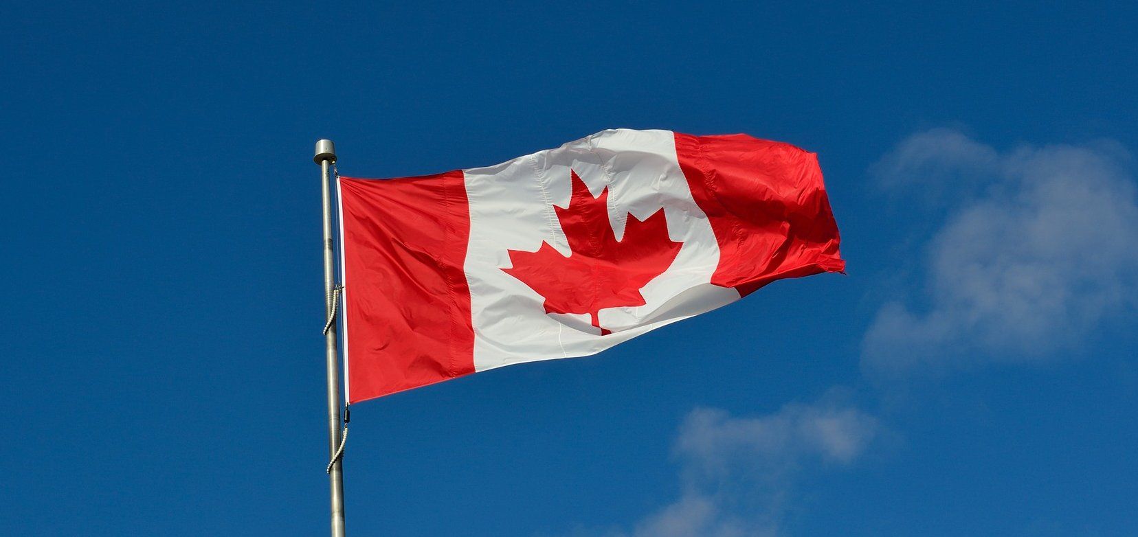 The Canadian flag waves in the breeze.