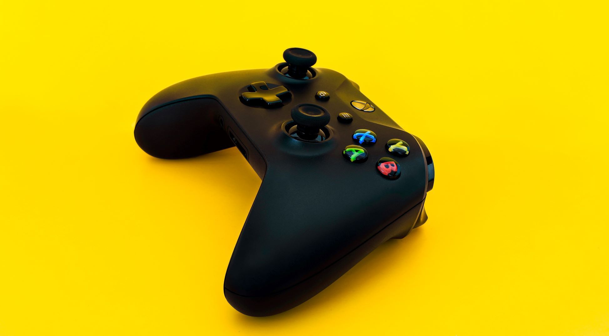 A top down photo of an Xbox Series X controller with a yellow background
